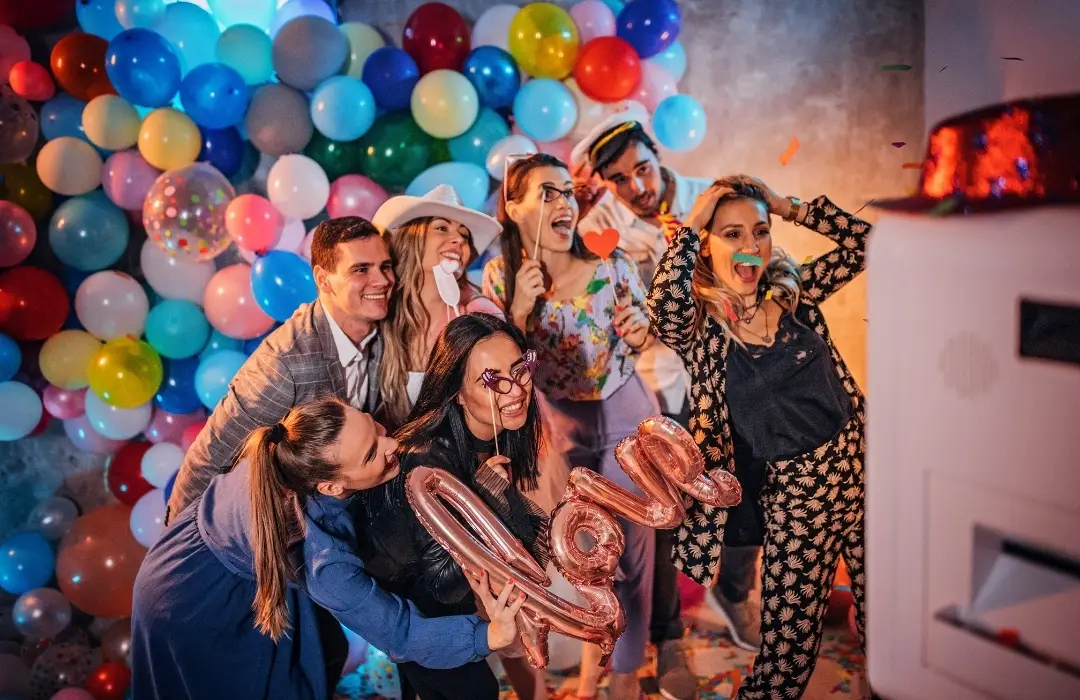 Invités souriants devant un photobooth lors d'un mariage en Île-de-France